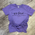 We Love Because He First Loved Us On Heather Purple Tee